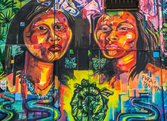 Buntes Graffiti mit indigenen Frauen auf Hauswand